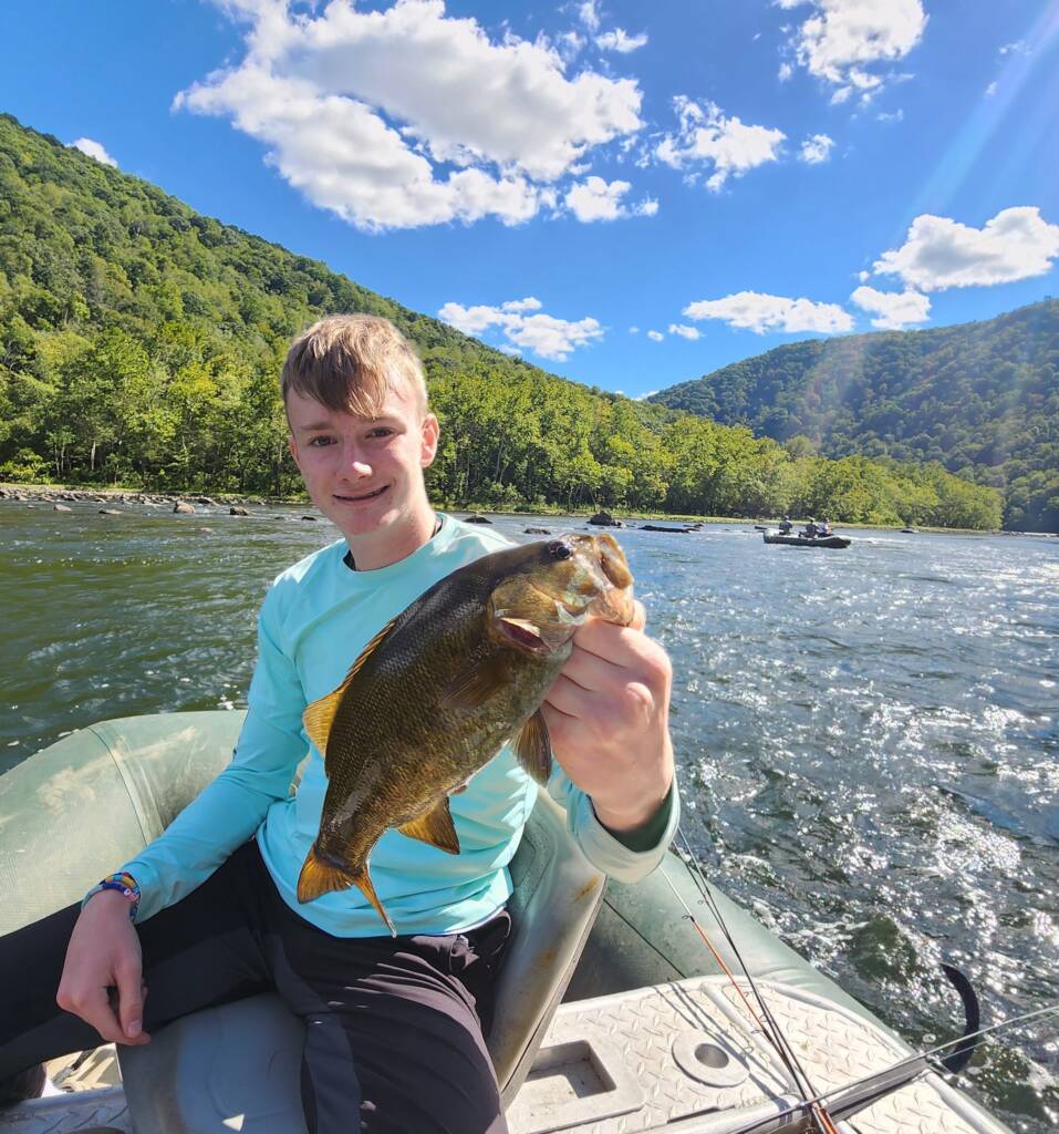 Teen Holding A Fish While On A Raft
